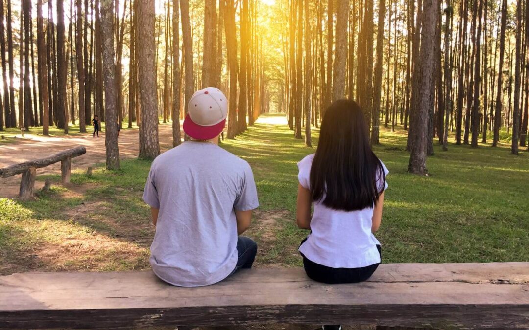 A couple with hyperhidrosis sitting on a bench at the park.